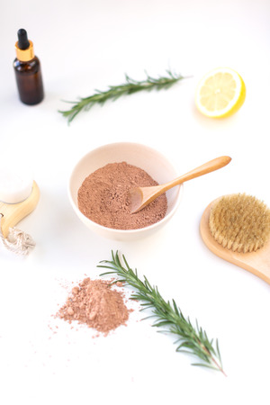 Moroccan red clay powder, wooden spoon, lemons and facial brush. Home skin care concept, easy spa procedures and detox. Minimal composition. Fashion and beauty blog.の写真素材