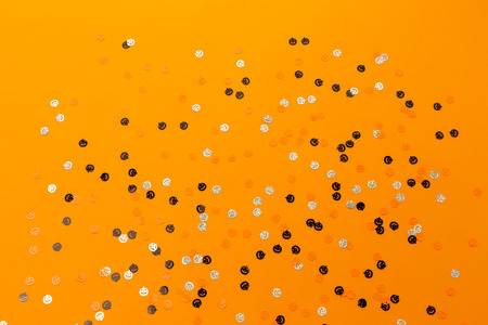 Halloween pumpkin shape colorful confetti on the bright orange background.Flat-lay, top view.の写真素材
