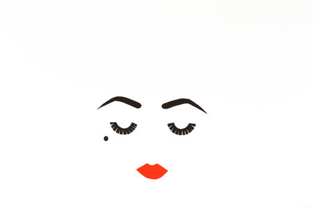 Paper made woman face with make up. Red lips, bold eye brows, long lashes and beauty spot. Copy...