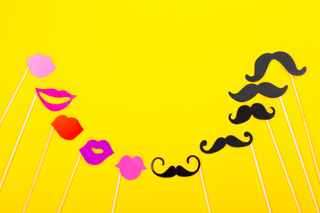 Photo booth props on the yellow background. Mustaches and lips. Top view, flat lay. Copy space for your text.の写真素材