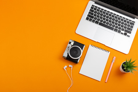 Creative feminine workplace with stationery supplies, laptop and camera. Travel or photography planning. Freelance, work at home or blogging concept. Bright colors. Copy space for your text.の写真素材