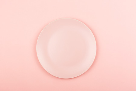 Empty pink plate on the pastel pink background. Flat lay, top view.の写真素材