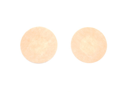 Nude nipple covers isolated on white background. Flat-lay, top view. Copy space for your text.