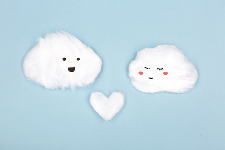 Two clouds made from cotton wool on blue background. Valentine day and love creative concept. Flat-lay, top view. Copy space for text.の写真素材