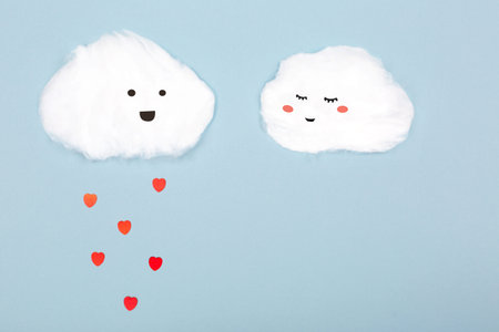 Two clouds made from cotton wool on blue background. Valentine day and love creative concept....