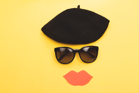 Fashion items beret, sunglasses and  big red lips on bright yellow background. Outfit of the day, accessories concept. Flat-lay, top view. Copy space.の写真素材