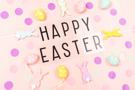 Happy Easter background. Holiday decor flat lay. Easter bunnies,  eggs and colorful confetti. Top view.の写真素材