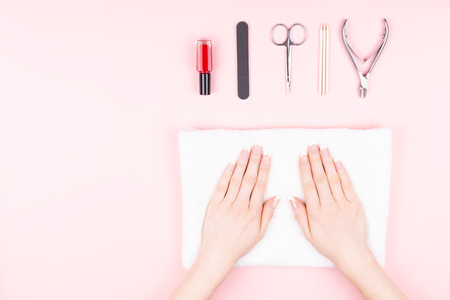 Beautiful woman hands and manicure tools on pink background. Hands and nails care concept. Flat-lay, top view. Copy space for text or design.の写真素材