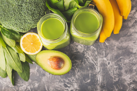 Green smoothie, greens, vegetable and fruits on moody background. Healthy eating, diet and vegetarian concept. Horizontal shot. Copy space for your text.の写真素材