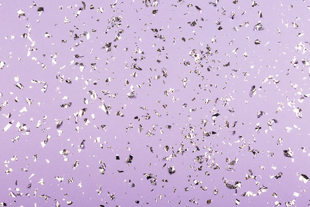 Silver confetti on purple background. Festive, party or holiday background. Flat-lay, top view.の写真素材