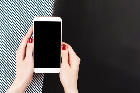 A smartphone in woman hands with perfect manicure.