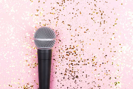 A microphone on pink background decorated with confetti. Minimal compostion.の写真素材