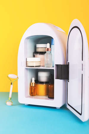 Mini fridge on yellow and blue background. Minimal composition.の写真素材