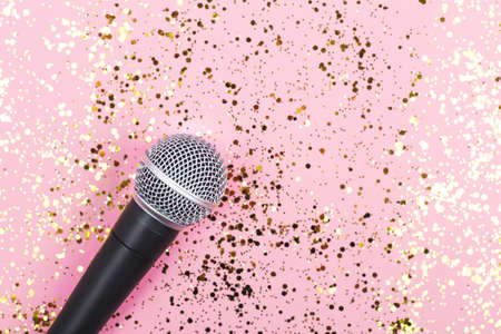 A microphone on pink background decorated with confetti. Minimal compostion.の写真素材