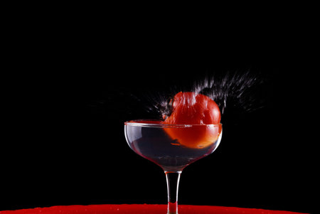 Tomato and glass isolated on black background