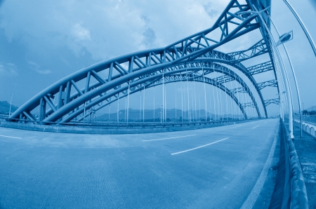 road through the bridge with blue sky background of a cityの写真素材