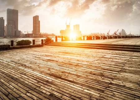 wooden platform before modern cityの写真素材