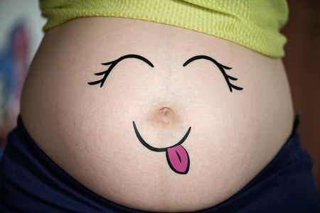 Portraits of cute baby in the pregnant woman's bellyの写真素材