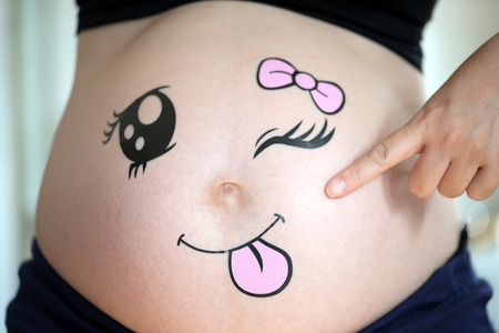 Portraits of cute baby in the pregnant woman's bellyの写真素材