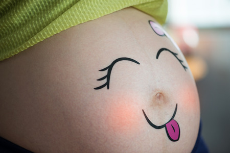 Portraits of cute baby in the pregnant woman's bellyの写真素材