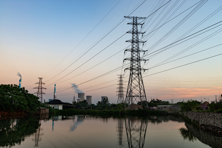 electricity transmission pylon silhouetted against blue skyのeditorial素材