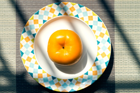 persimmon fruits in the fruit bowlの写真素材