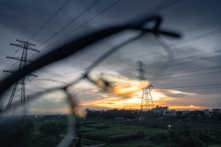 electricity transmission pylon silhouetted against blue sky at dusk