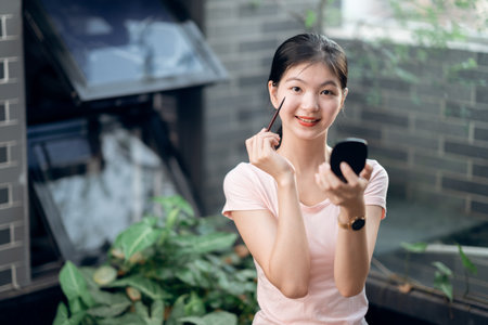 Asian girls make up in the courtyardの写真素材