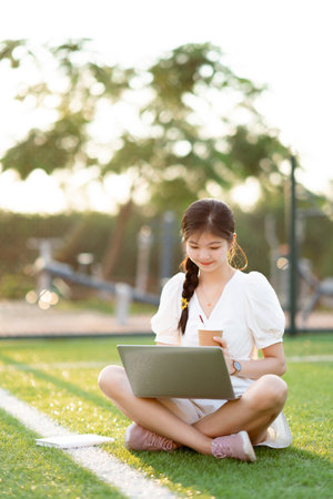 College students use laptops in football fieldsの写真素材