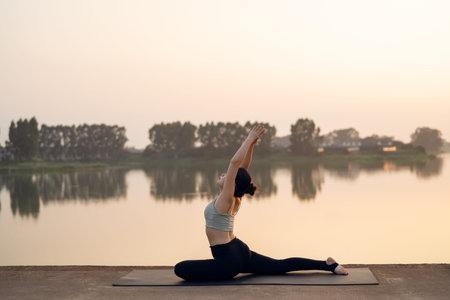 The girl is doing yoga by the lake