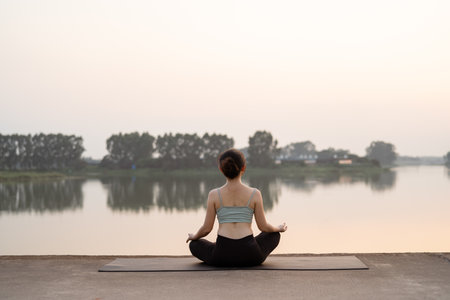 the girl is doing yoga by the lakeの写真素材