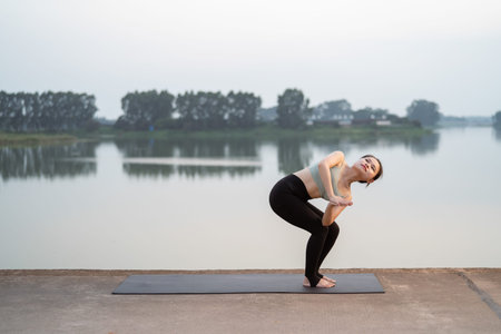 the girl is doing yoga by the lake