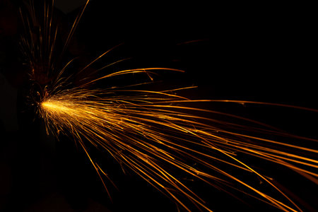 metal cutting saw close up throwing sparks all over in a workshopの写真素材