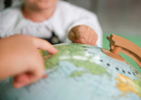 Little girls run their fingers over the globe. close-up Selective focus on the globe.の写真素材