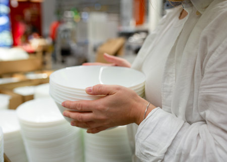 A young woman chooses dishes in a store, Close-up of handsの写真素材
