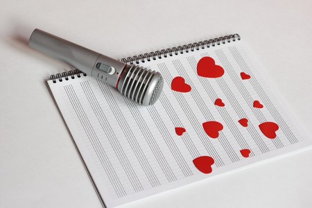 Microphone and paper red hearts are located on a clean music notebook. The concept of music and love. Valentines dayの写真素材