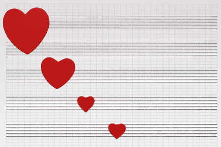 Love, music and hearts. Valentines day. Hearts of red paper lie on a clean music notebook. The concept of music and love.の写真素材