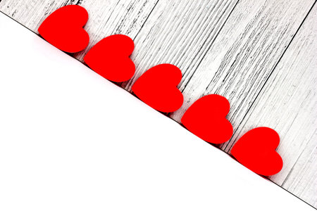 Red cardboard hearts are arranged in a row. Design and decoration for Valentine's Day. concept of...