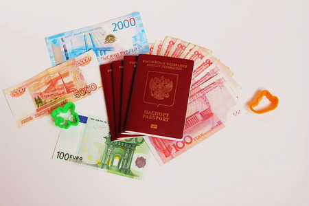 The passport of the Russian Federation. Biometric russian passports, rubles and euro and yuan for the trip. Plastic figures of the ship and the plane.の写真素材