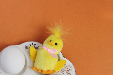White chicken egg and toy chicken are on the plate. happy Easter. Symbol of new life. empty space...