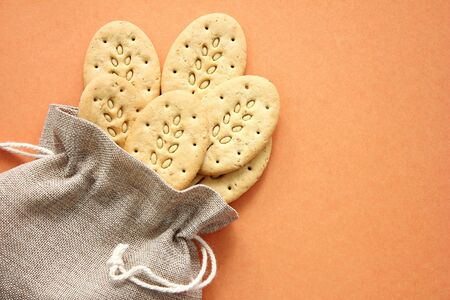 Reusable canvas bag and multicereal biscuits on brown background . Care for the environment and health.の写真素材