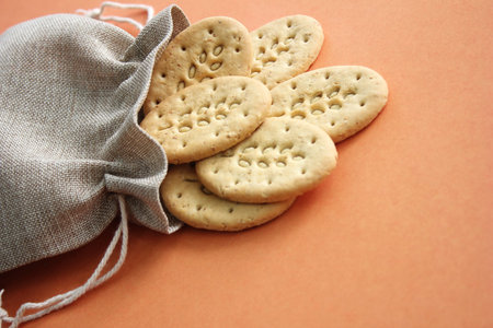Reusable canvas bag and multicereal biscuits on brown background . Care for the environment and...