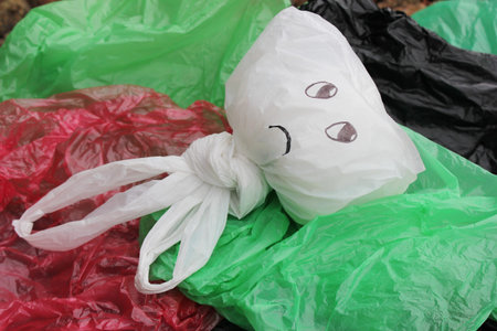 A bunch of disposable, multi-colored plastic bags polluting the environment. Sad facial expression...