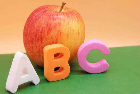 English ABC alphabet letters next to book and apple. Learning foreign language. English for...