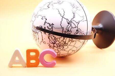 English ABC alphabet letters next to black and white globe. Learning foreign language. English for beginners. International languageの写真素材
