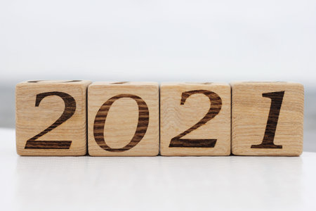 Wooden blocks with the numbers 2021 lie in the open air. Happy New year.