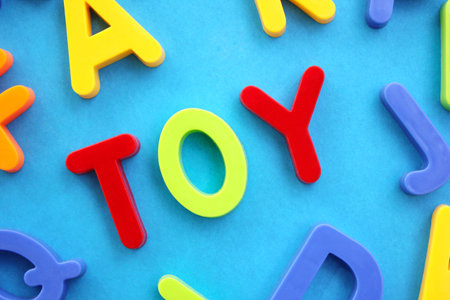 The word Toy is laid out in colored plastic letters of the English alphabet on a blue background.の写真素材