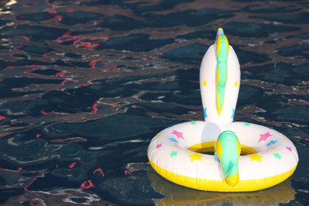 A swimming circle in the form of a unicorn is floating in the pool. Concept of summer holidays....