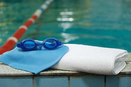 swimming pool. accessory for the pool - a towel, a rubber cap and swimming goggles.の写真素材