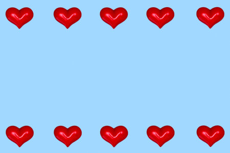Valentine's Day greeting card. Red hearts in a row on a blue background. A frame of hearts. Copy...